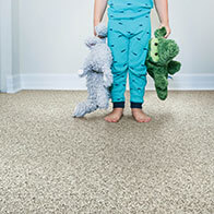 Child with toys on grey carpet | Flooring 101